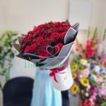 A white box containing 20 red roses and 10 maroon chrysanthemums
