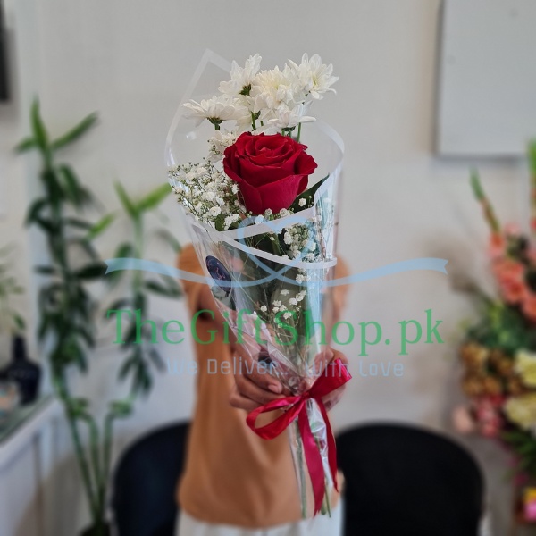 A single imported red rose with a stem of chrysanthemum and baby’s breath wrapped in a paper with a ribbon