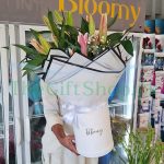 a bouquet of 8 pink and white lilies in a white box.
