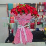 A bouquet of 4 dozen local red roses wrapped in a pink paper with a white ribbon