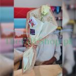 A photo of a bouquet of white roses and baby’s breath wrapped in white paper