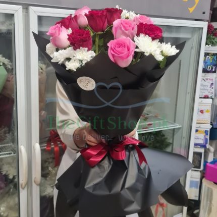 Romantic Rhapsody: A bouquet of 5 red roses, 5 pink roses, and 4 white chrysanthemums wrapped in black paper with a red ribbon
