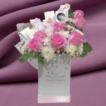 Opulent Rosette Delight: Elegant floral arrangement with pink roses, white chrysanthemums, gypsophila, and mixed chocolates in a white box