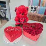 Romantic gift combo featuring a red plush teddy bear, heart-shaped cake, and red roses presented in a heart-shaped box. Perfect for expressing love to someone in Pakistan.